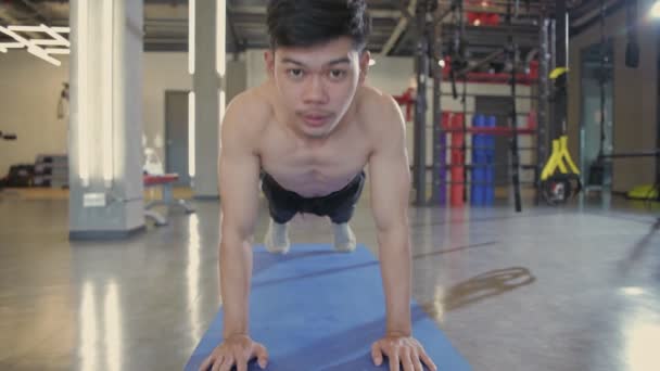 フィットネスコンセプト ジムで運動マットを押しているアジア人の男 4K分解能 — ストック動画