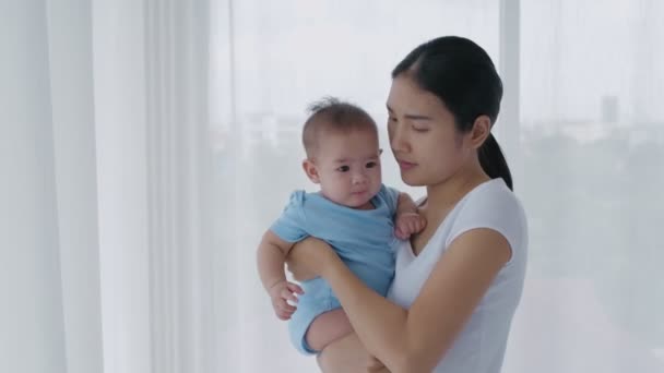 家族の概念 アジア系の母親が家で赤ん坊を抱えている 4K分解能 — ストック動画
