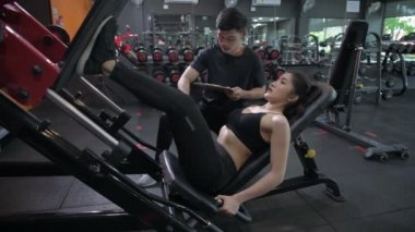 Fitness konsepti. Antrenör spor salonunda egzersiz yapan Asyalı kadınlarla ilgilenir. 4k Çözünürlüğü.
