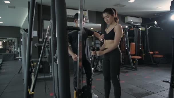 フィットネスコンセプト アジアの女性はスポーツジムでローイングマシンの重みを行使します 4K分解能 — ストック動画