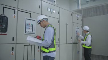 Mühendis konsepti. Teknisyen takım liderini bir iletişim cihazıyla koordine ediyor. 4k Çözünürlüğü.