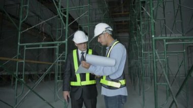 Mühendis konsepti. İş adamları bina genişletme işini tartışıyor. 4k Çözünürlüğü.