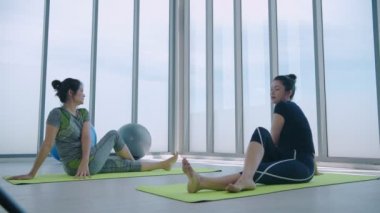 Egzersiz konsepti. Spor salonunda esneme hareketleri yapan bayan sporcular. 4k Çözünürlüğü.