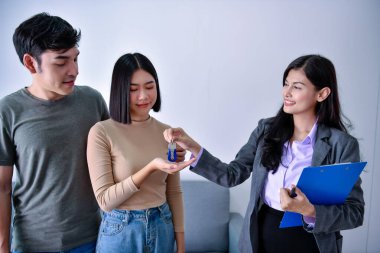 Ofis ortamındaki bir çiftle ürün faydalarını tartışan bir danışman..