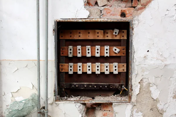 Zerstörter Alter Sicherungskasten Umgeben Von Bröckelnder Mauer Sichtbaren Ziegeln Heizkörperrohren lizenzfreie Stockfotos