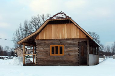 Soğuk kış gününde taze düşmüş kar ile çevrili yenilenmiş ahşap günlük kır evi