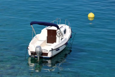 Sıcak güneşli bir gün sakin açık mavi deniz ile çevrili parlak sarı şamandıra yerel limana bağlı dıştan tekne motor ile yeni beyaz tekne