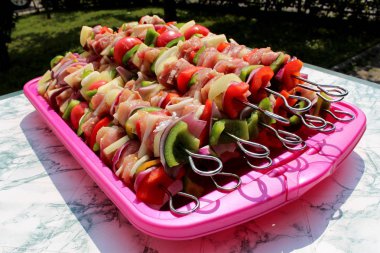 Taze domates, kırmızı ve yeşil biber, soğan, pastırma ve et içeren ızgara için hazır taze hazırlanmış et ve sebze sağlıklı kebaplar daha kolay ızgara için metal sivri koymak