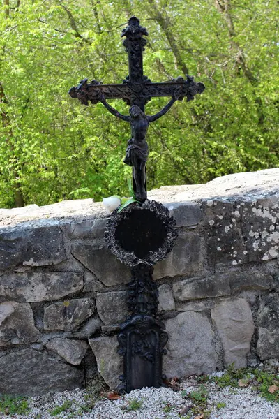Antikes Grabstein Kreuz Aus Dunklem Metall Vor Steinmauer Und Pflanzen — Stockfoto