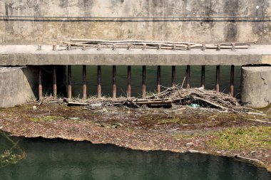 Sıcak yaz gününde gelen suda yüzen dalları ve çöp önlemek için set sert beton baraj duvara monte edilmiş paslanmış metal çubuklar