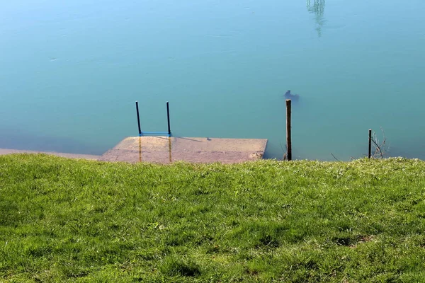 Ungemähtes Grasbewachsenes Flussufer Mit Kleinem Überfluteten Betonpier Mit Metallstufen Warmen — Stockfoto