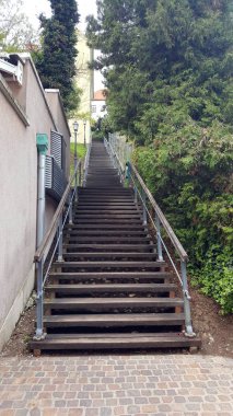 Ahşap şehir adımları ile metal el çubukları ve antika barok ışık ağaç aşırı büyüme ile çevrili