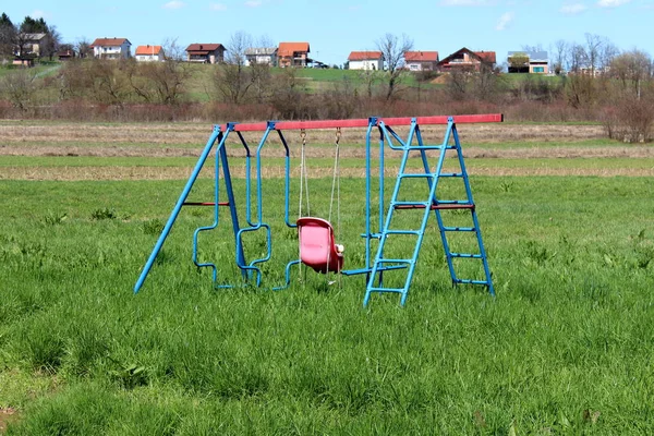 Outdoor Spielgeräte Metallschaukel Mit Verblichenem Blauem Rahmen Und Marodem Kunststoffsitz — Stockfoto