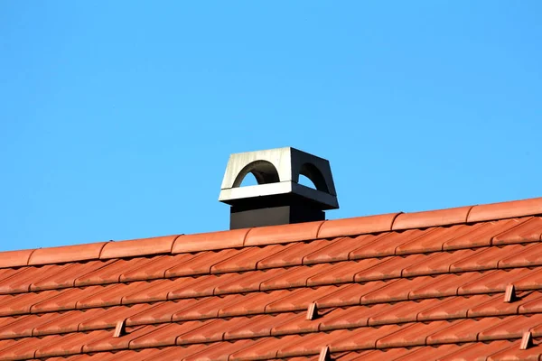 新的混凝土烟囱建在家庭房屋的顶部 在晴朗的蓝天背景上用新的屋顶瓦片和防雪罩 — 图库照片