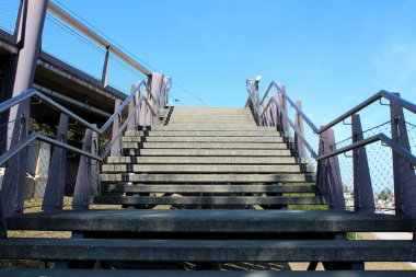 Açık havada geniş beton merdivenler, sıcak yaz günlerinde yerel tren istasyonuna giden oklar ve tel korkuluklarla çevrili.