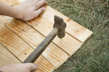 Ana çekiç çivi bir ahşap tahta çim içine