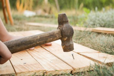 Ana çekiç çivi bir ahşap tahta çim içine