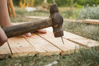 Ana çekiç çivi bir ahşap tahta çim içine