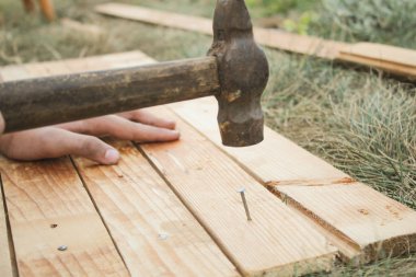 Ana çekiç çivi bir ahşap tahta çim içine