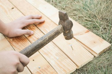 Ana çekiç çivi bir ahşap tahta çim içine