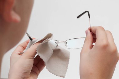 Peçeteli bir el beyaz arka planda bardakları siler..