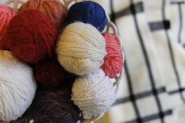 Örgü ve konfor. İplik, örgü iğneleri, sepet renkli toplar. Homecomfort iğne işi
