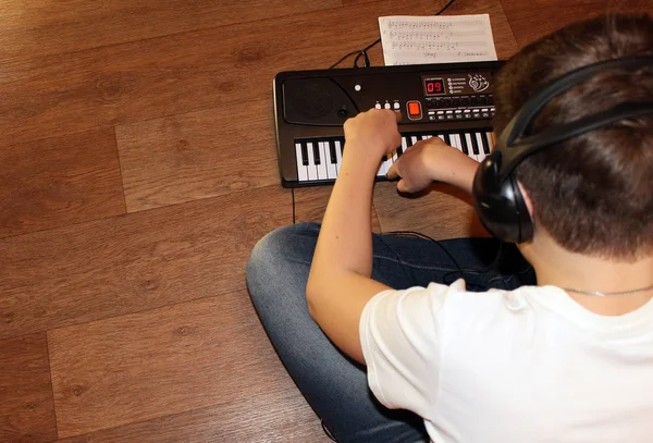 Primer plano de un adolescente enfocado jugando en el teclado en el suelo —  Fotos de Stock