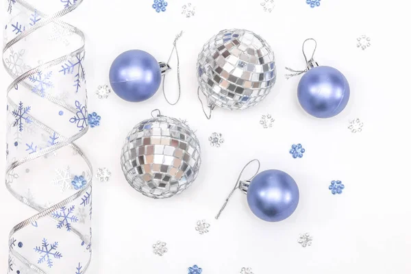 Christmas composition. Christmas balls, blue and silver decorations on white background. Top view, copy space.