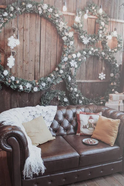 Pokój jest urządzony na nowy rok. Wieńce na Boże Narodzenie, biały koc i poduszki na kanapie. — Zdjęcie stockowe