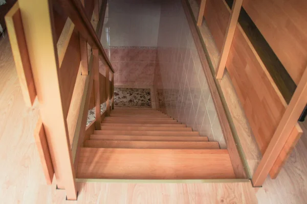 Vista superior de una nueva escalera de madera con barandilla iluminada por una ventana —  Fotos de Stock
