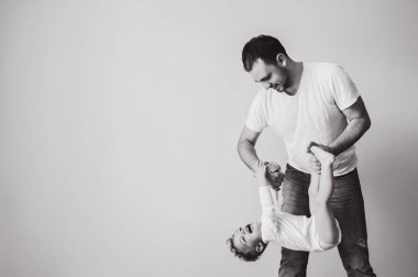 black and white photo of father playing together with little son at home clipart