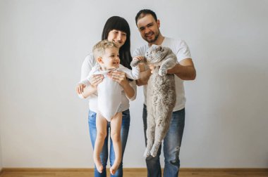 mutlu anne küçük yürümeye başlayan çocuk ve gri kedi evde tutan portresi