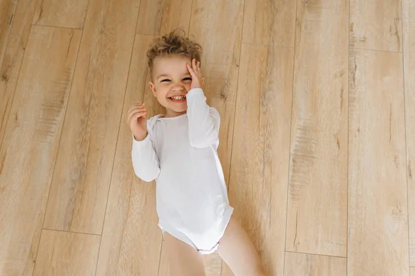 Vista Aérea Menino Sorridente Bonito Bodysuit Branco Deitado Chão Casa — Fotografia de Stock