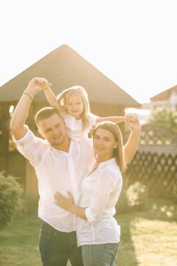 Baba ve anne .arka bahçesine yakınındaki beklemede iken piggybacking gülümseyen kız portresi