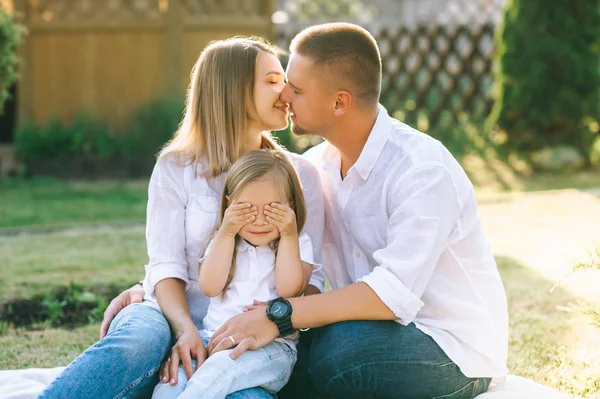 Anne küçük kızı birlikte arka bahçesinde üzerinde dinlenme süre gözlerini kapsayan süre öpüşme