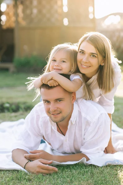 küçük kızı kumaş zemin üzerine arka bahçesinde birlikte dinlenme ile mutlu aile