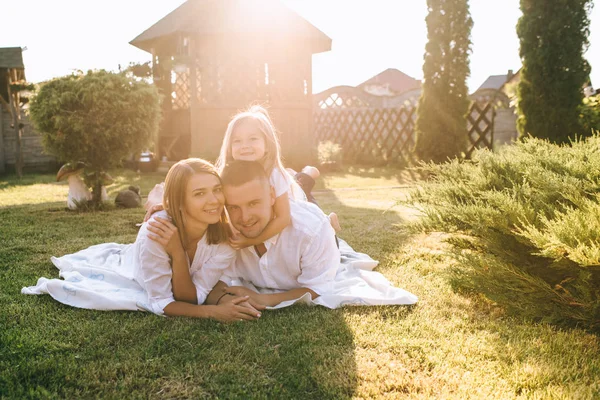 Anne ve küçük kızı kumaş zemin üzerine arka bahçesinde birlikte dinlenme gülümseyen