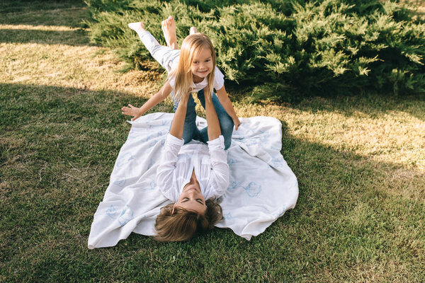 mother and cute little daughter having fun together on backyard