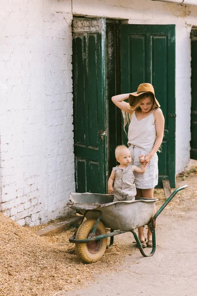 Woman Holding Sons Hand While Standing Wheelbarrow Countryside — Stock Photo, Image
