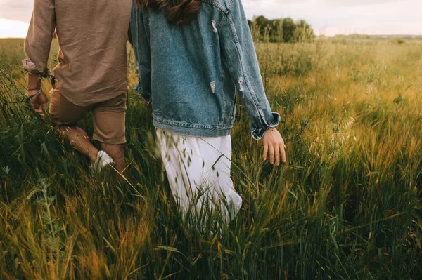 夏の緑の草原の上を歩いてスタイリッシュなカップルのビューをトリミング — ストック写真