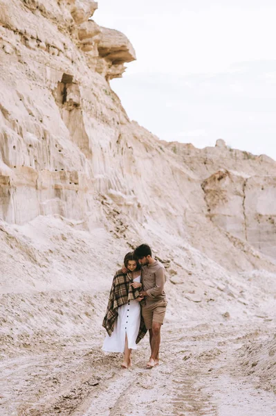 Young Couple Hugging Blanket Walking Sand Canyon — Free Stock Photo