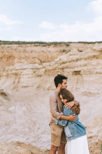 砂の渓谷で美しい恋人を抱いて幸せな彼氏 — ストック写真
