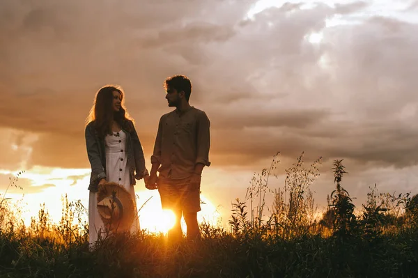 Silhouette Eines Paares Das Sich Bei Sonnenuntergang Auf Einer Wiese — Stockfoto