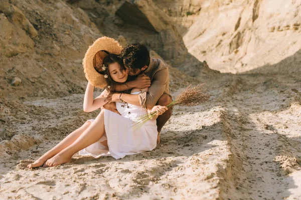 Boyfriend Embracing Girlfriend Straw Hat Floral Bouquet While Sitting Sand — Stock Photo, Image