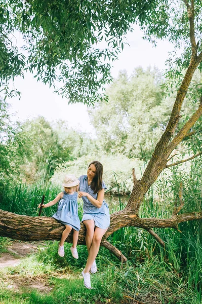 Stylish Mother Daughter Sitting Tree Trunk Together — Free Stock Photo