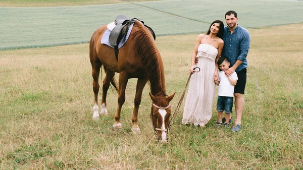 Eltern Und Sohn Stehen Mit Pferd Auf Feld — kostenloses Stockfoto