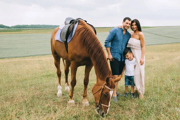 Lächelnde Eltern Und Sohn Stehen Mit Pferd Auf Dem Feld — Stockfoto