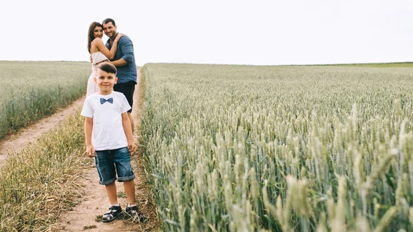 Genitori Abbracciare Figlio Guardando Fotocamera Sul Percorso Nel Campo — Foto Stock