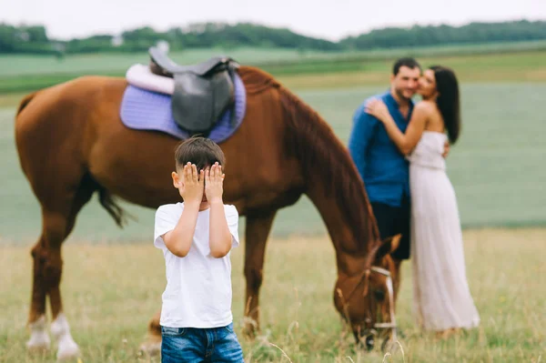 Eltern Umarmen Sich Und Sohn Verdeckt Augen Auf Feld — Stockfoto