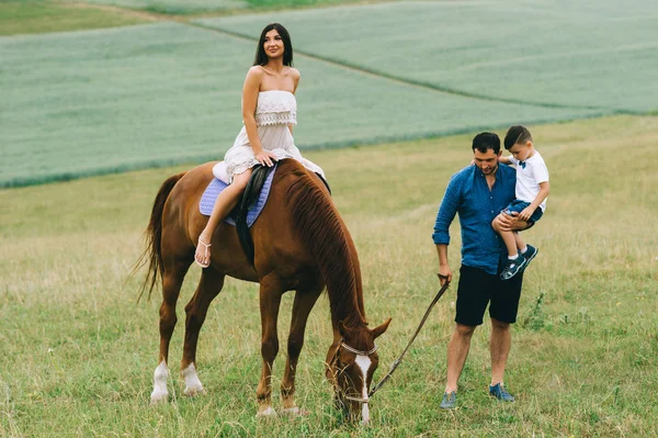 Moeder Rijden Bruin Paard Vader Met Zoon Permanent Veld — Gratis stockfoto